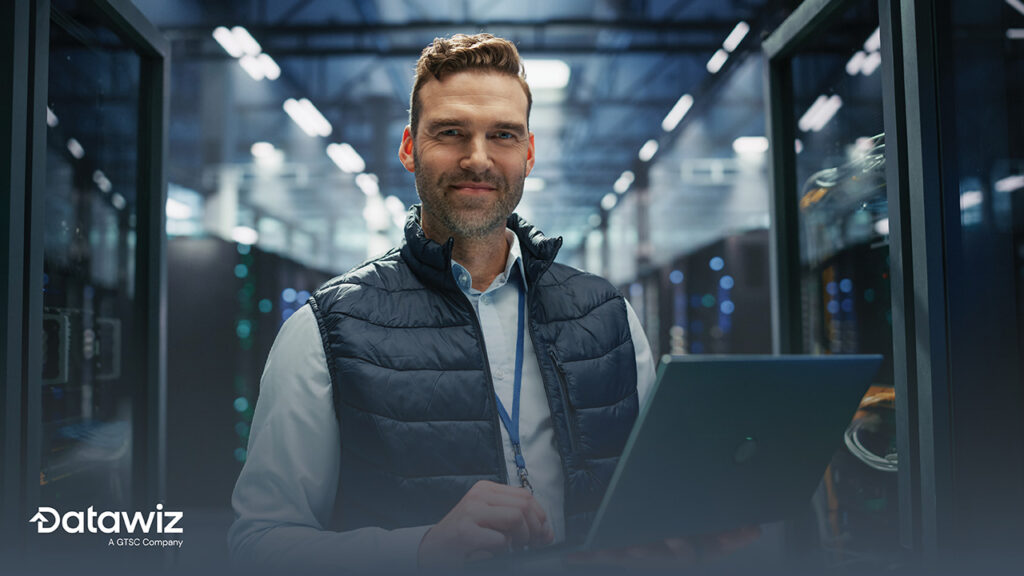Professional in data center holding laptop looking confident